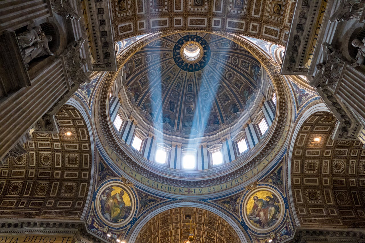 Sunlight streams through the dome of St. Peter's Basilica, revealing intricate frescoes and architecture in Vatican City.